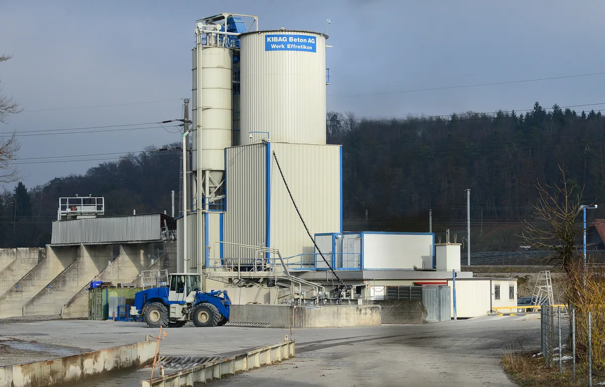 Ein blauer Bulldozer vor einem Silogebäude.